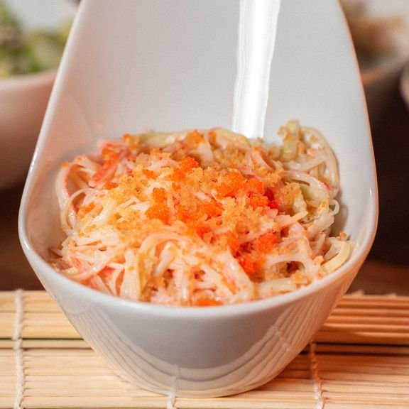 Kani Salad Japanese style salad made with crab stick, cucumber and masago with a creamy spicy mayonnaise dressing, and topped with crunchy flakes.